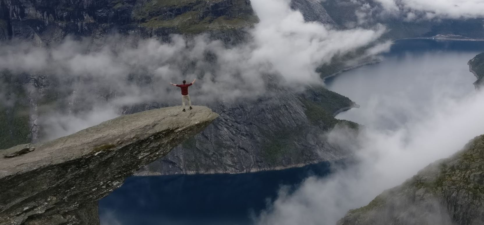 standing on the trolltunga in norway freedom and happiness