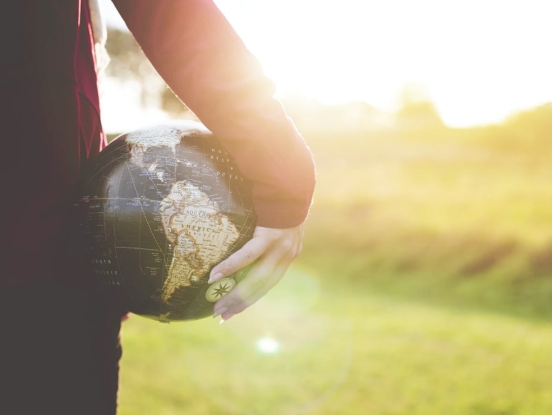 person holding globe in hand