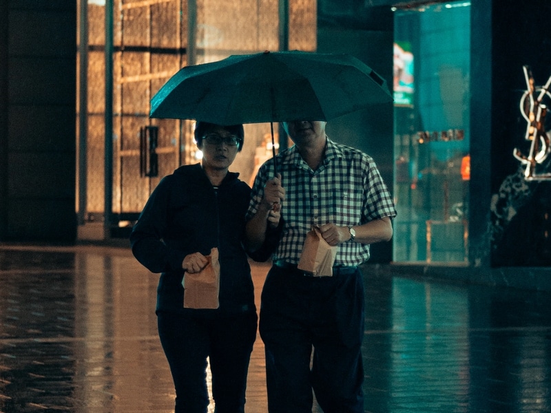 couple walking under umbrella rain