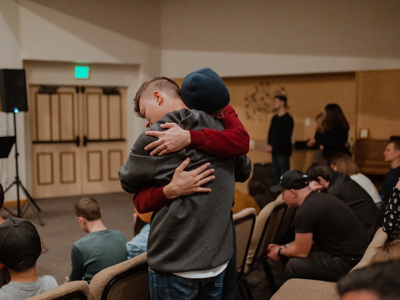 men hugging in classroom