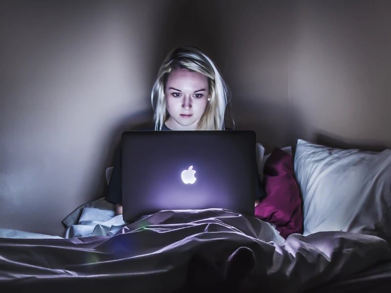 woman on laptop at night in bed