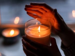 hands around candle light