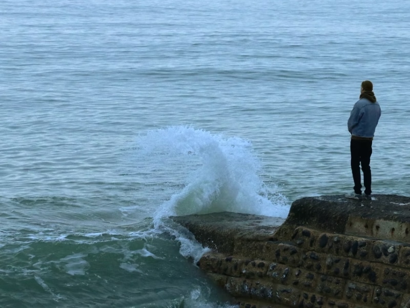 man standing by ocean waves