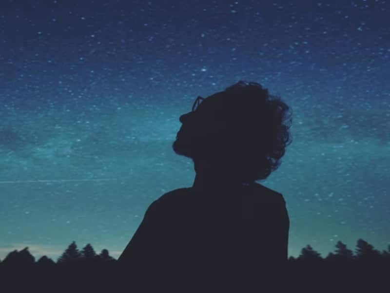 man staring at stars at night