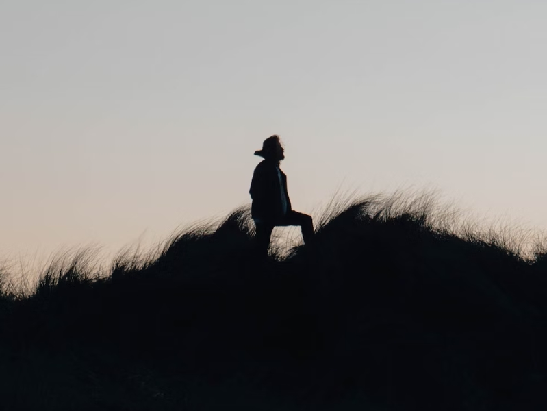 person silhouette on dunes