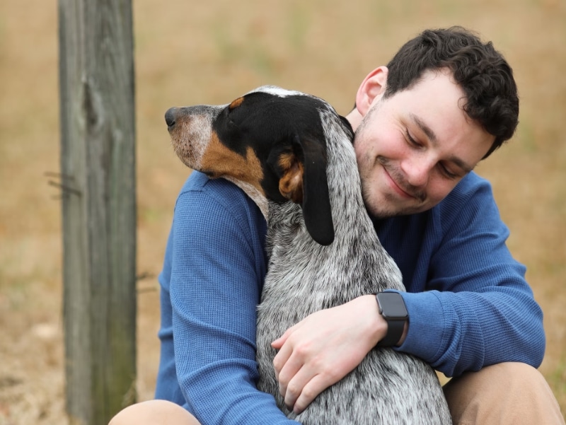 happy man cuddling with dog