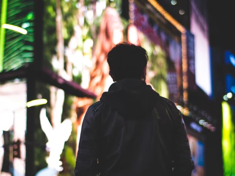 man standing in city lights