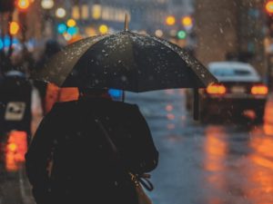 person walking in rain at night