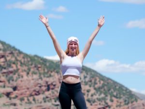 woman cheering on top of mountain