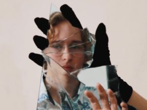 woman looking at reflection in broken mirror