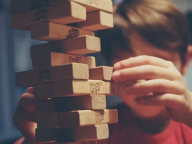 boy building jenga tower of blocks