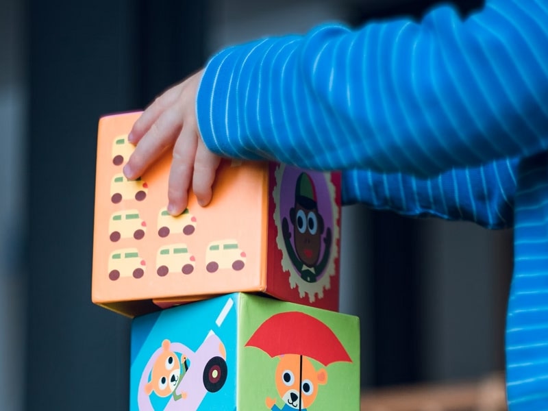 child stacking boxes