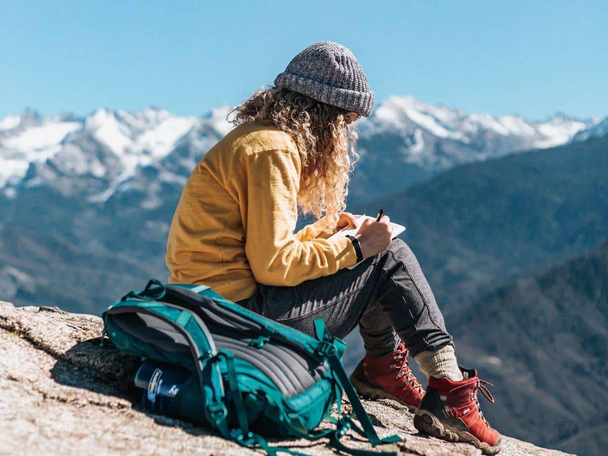 woman writing on a mountain