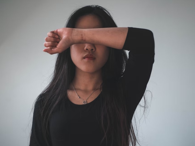 woman covering eyes with hand