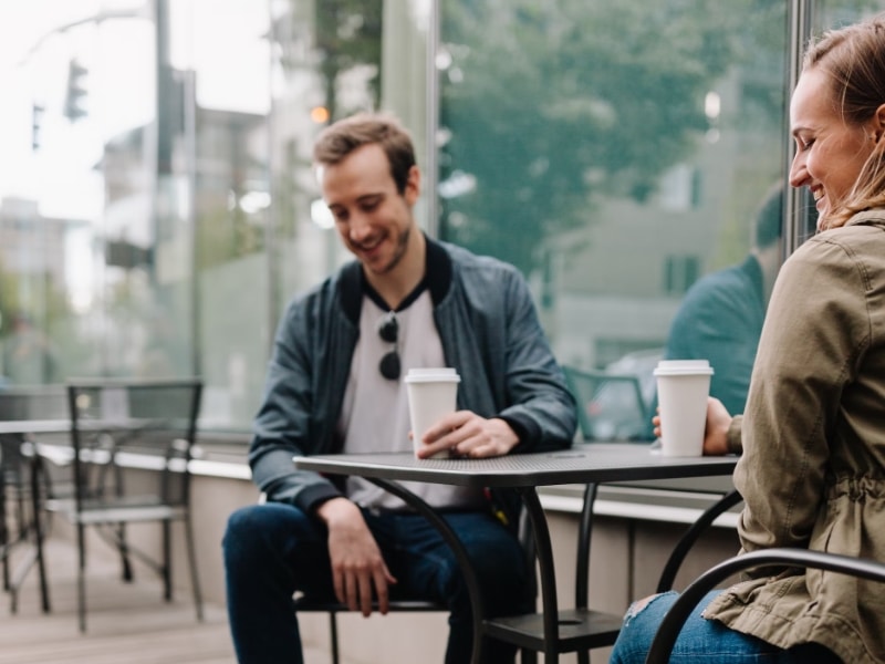 man and woman drinking coffee outside