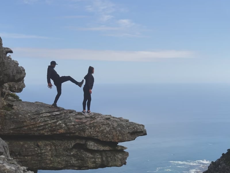 man fake kicking woman off cliff