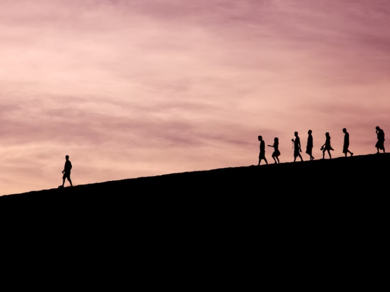 people following leader on mountain background silhouette