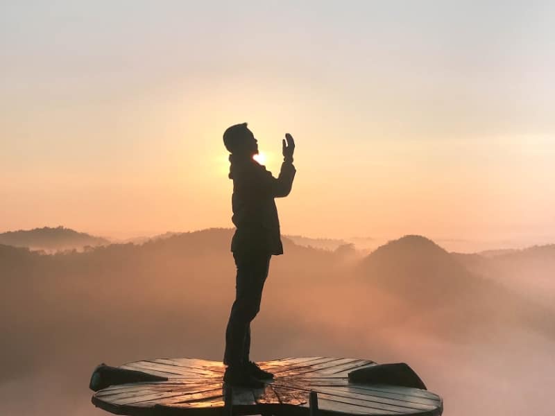 person standing on tower in front of mountains