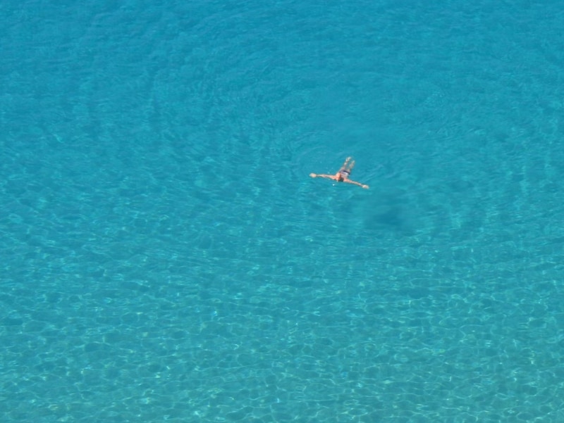 person floating in blue water