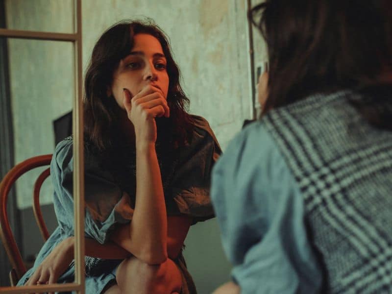 women thinking in front of mirror