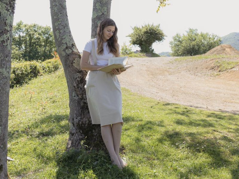 women reading a book in a park