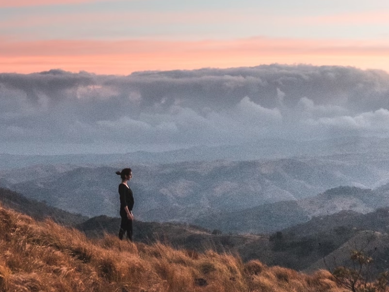 person looking over hills with colors