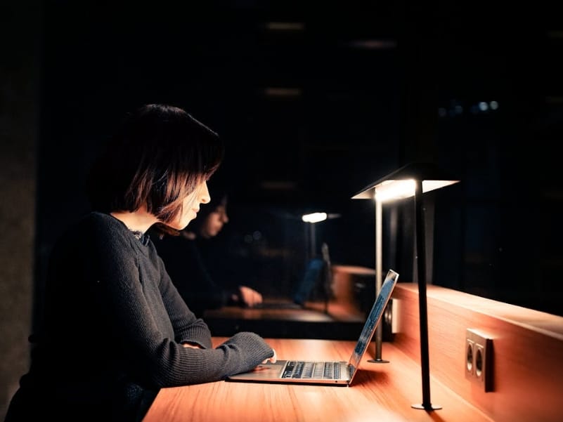 woman working on laptop in dark